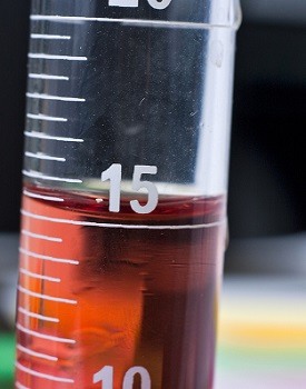 A test tube with a liquid in it. The liquid curves up at the surface.