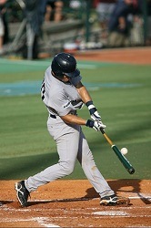 A baseball player swings at a pitch.