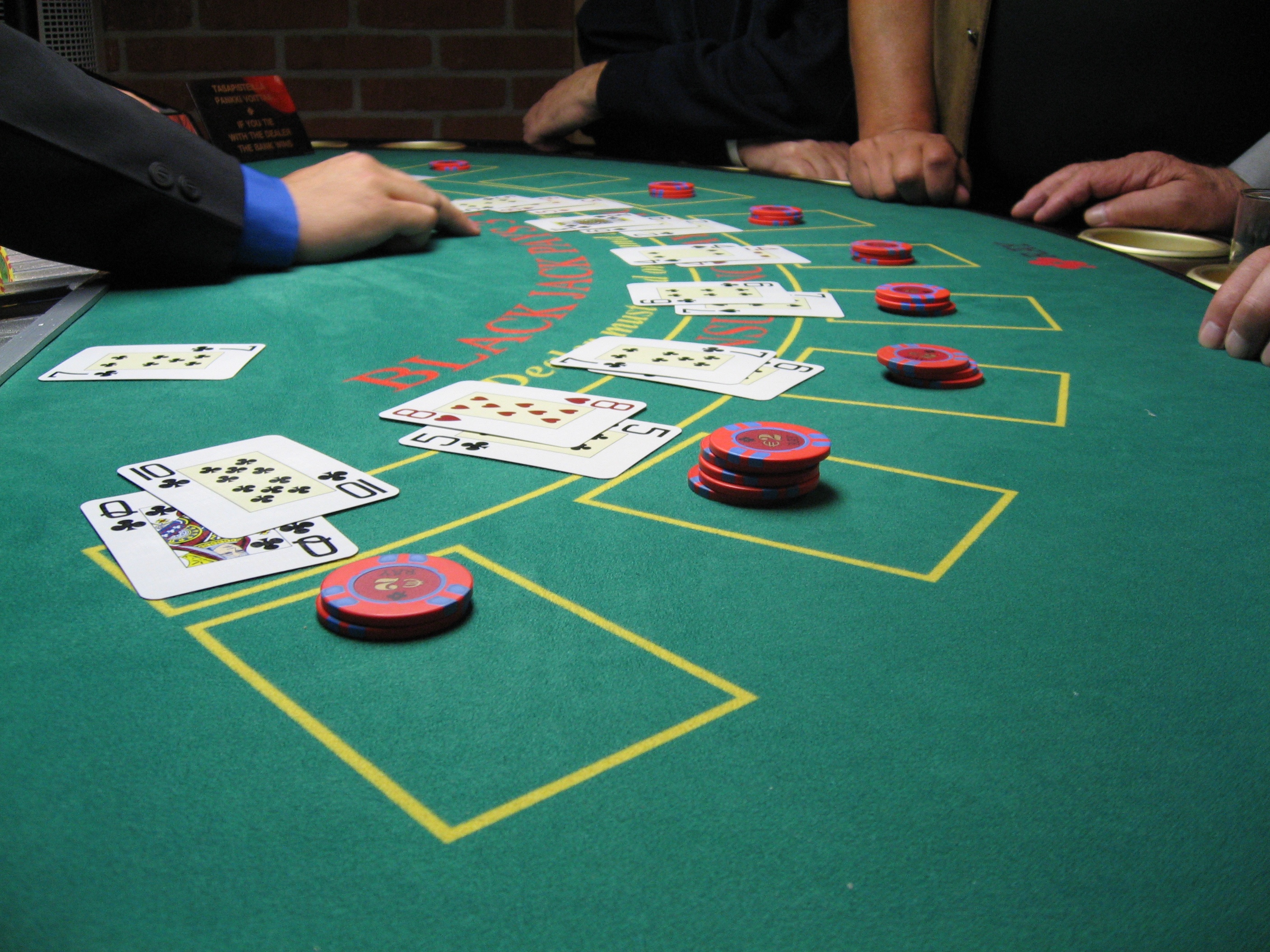Blackjack table with cards and chips stacked throughout, in the middle of a game