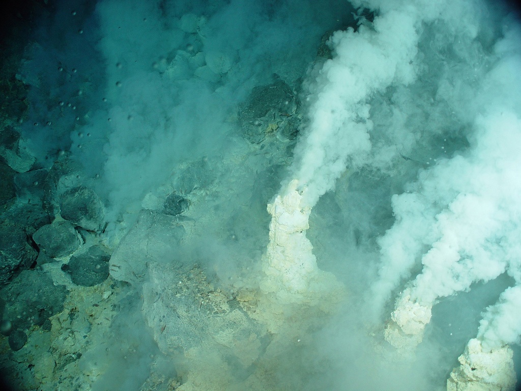 The image shows deep sea vents emitting cloudy jets of carbon compounds.