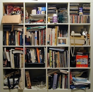 A messy bookshelf containing a 4 x 4 grid of disheveled books