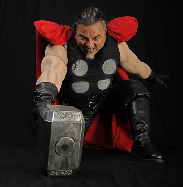 Thor is wielding his godly hammer, in the shape of a rectangular prism
