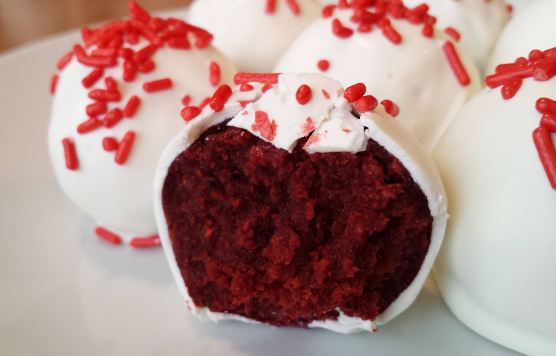 Chocolate cake wrapped in vanilla icing and red sprinkles