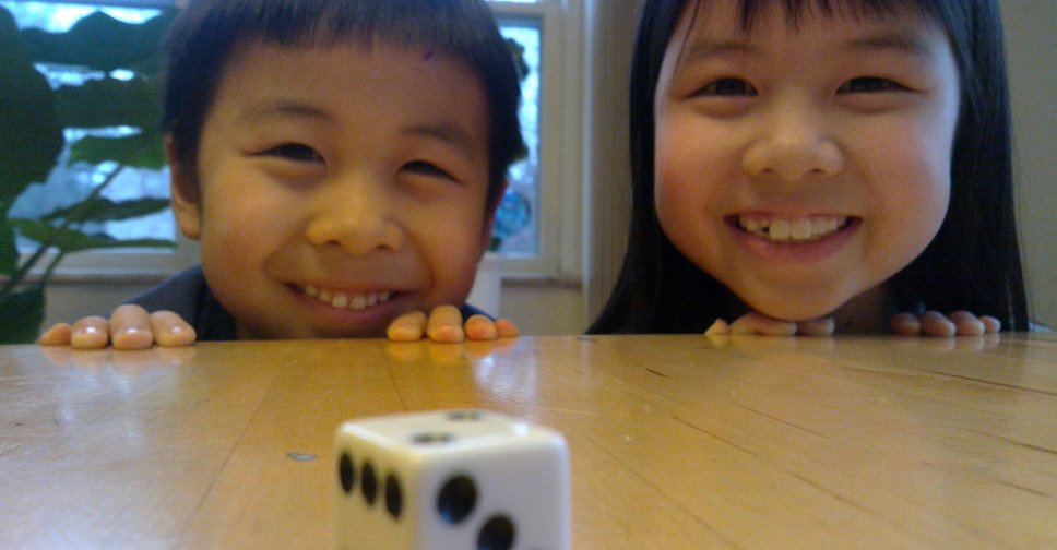 Two kids ready to roll a die.