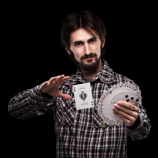 A picture of a magician doing a card trick.