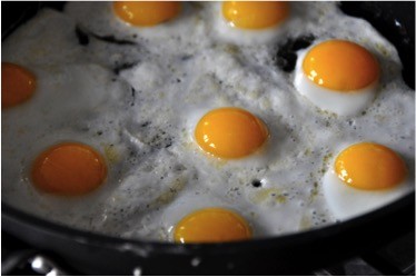 Eggs frying in a pan.