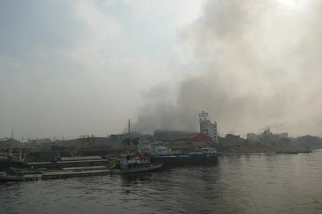 A factory causes air pollution on the banks of a river.