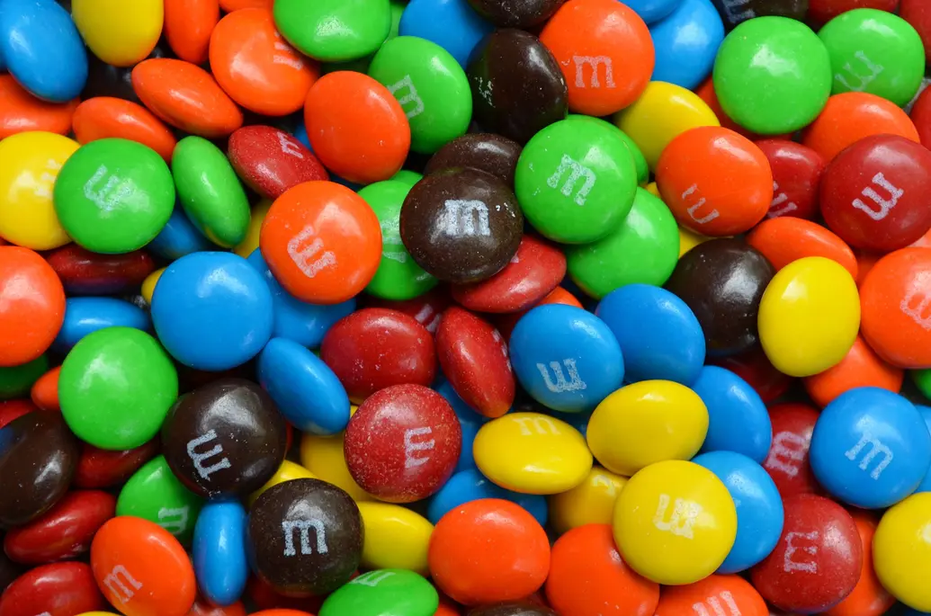 The contents of a colorful bag of M&Ms: red, orange, blue, yellow, green, and brown
