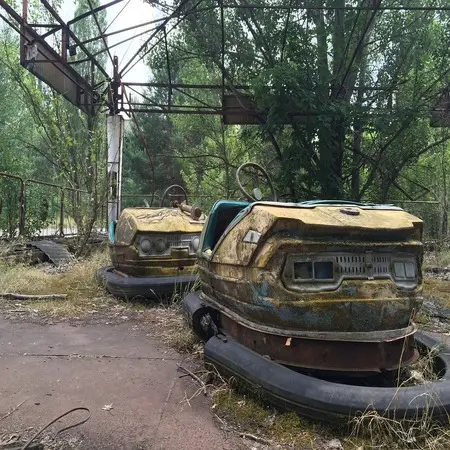 The image shows abandoned bumper cars in Pripyat, Russia.