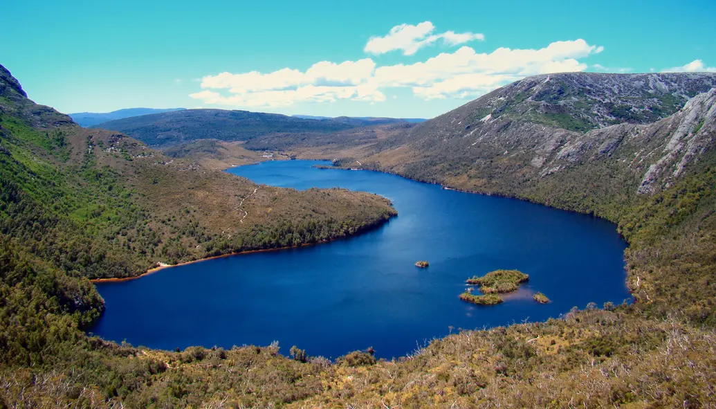A lake surrounded by hills and many plants