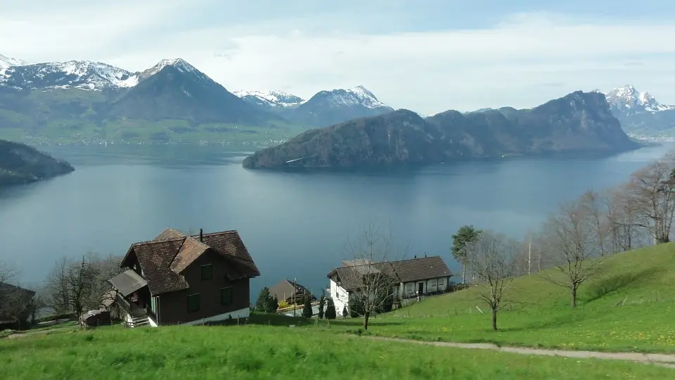 A standing freshwater biome with mountains in the back and a house along its edge.